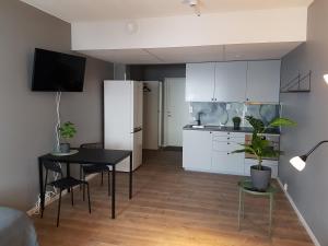 乌普萨拉Apartments Uppsala - Portalgatan的厨房以及带桌子和冰箱的用餐室