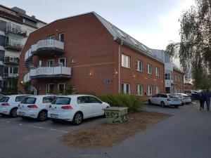 乌普萨拉Apartments Uppsala - Portalgatan的停在大楼前停车场的一群汽车