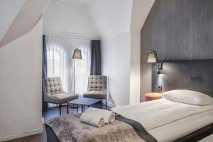 奥斯陆K7 Hotel Oslo的一间卧室配有一张大床和两把椅子