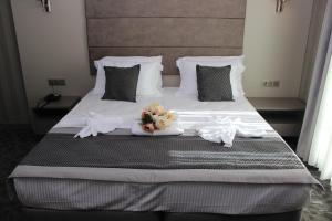 伊斯坦布尔Anka Premium Hotel的一张配有白色床单和鲜花的大床