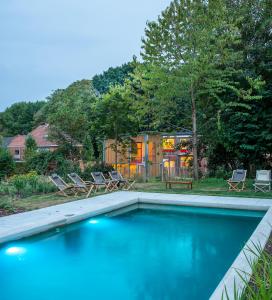 BazelBAZ holiday homes的一个带两把椅子的游泳池以及一座房子