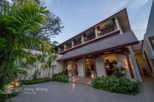 清迈Villa Klang Wiang的享有棕榈树建筑的外部景色