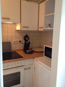 杜塞尔多夫Messewohnung Düsseldorf-Nord的小厨房配有白色橱柜和微波炉