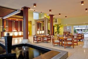 库塔拉尼酒店及水疗中心的一间带桌椅的餐厅和一个游泳池