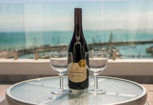 戈登湾Bikini Beach Penthouse的桌子上放有一瓶葡萄酒和两杯酒