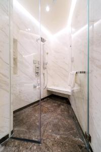 香港香港嘉賦酒店的一间带玻璃淋浴间和长凳的浴室