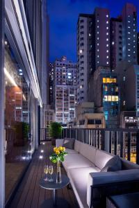 香港香港嘉賦酒店的阳台配有沙发和带酒杯的桌子。