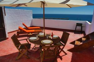 大塔拉哈尔Casa Miramar的庭院配有桌椅和遮阳伞。