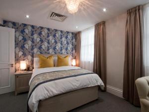 伦敦W12客房旅馆的一间卧室配有一张床和一个吊灯