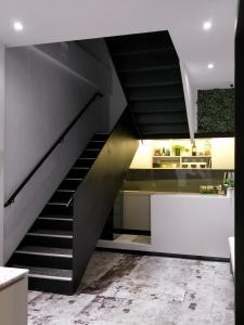 罗东镇小小邸 Small Hotel的楼梯通往带柜台的厨房