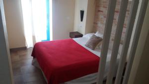 泰拜尔盖La Trancada的一间卧室配有一张带红色毯子的床