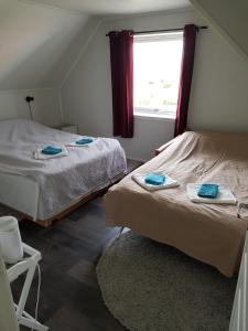 伊温斯科尔1 Room in The Yellow House, close to Airport & Lofoten的一间卧室配有两张带毛巾的床