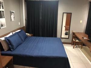 洛雷纳Summit Dom Apart Hotel的一间卧室配有蓝色的床和一张书桌