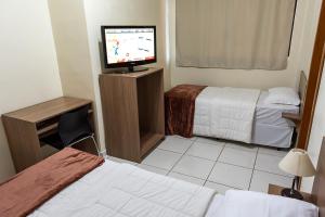 伊茹伊Hotel D'Nápoles的酒店客房设有两张床和一台平面电视。