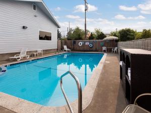 格兰茨帕斯Red Lion Inn & Suites Grants Pass的一座房子前面的蓝色海水游泳池