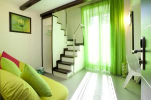 索伦托索伦托费拉特斯酒店的客厅设有绿色沙发和楼梯。
