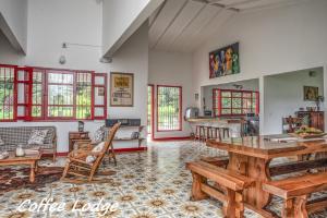 马尼萨莱斯Hacienda Venecia Coffee Farm Hotel的厨房以及带桌椅的起居室。