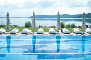萨潘贾里士满诺健康Spa酒店 - 仅限成人酒店的一个带遮阳伞和水体的游泳池
