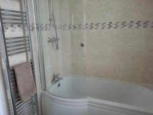 马基特德雷顿城堡宾馆的设有带浴缸和淋浴的浴室。