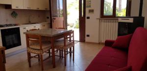 弗切瓦拉诺Appartamento Gargano的厨房配有桌椅和红色沙发