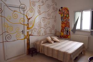 奥斯图尼B&B La casa degli artisti的卧室墙上涂有一棵树