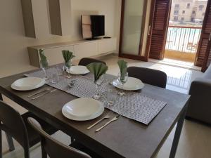 MġarrFort Cambray Apartment with Spectacular Sea Views的餐桌,上面有盘子和玻璃杯