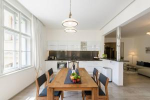 布拉格Stylish, Light-Filled Home in the Historic Center的厨房以及带木桌和椅子的用餐室。