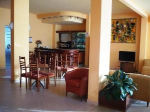 蒂勒尼亚佛罗里达伦尼亚酒店的餐厅设有酒吧,配有椅子和桌子