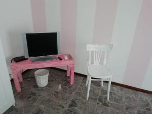 塞拉瓦莱·斯克里维亚Good Morning Shopping的一张带笔记本电脑和椅子的粉红色办公桌