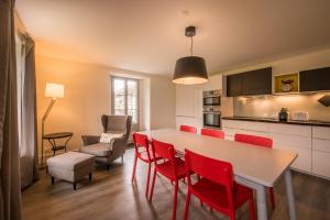 因特拉肯Dependance Penthouse的厨房以及带桌子和红色椅子的用餐室。