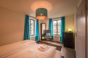 因特拉肯Dependance Penthouse的一间卧室配有两张带蓝色窗帘和吊灯的床。