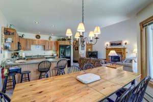 JayJay Peak Townhouse的厨房以及带木桌和椅子的客厅。