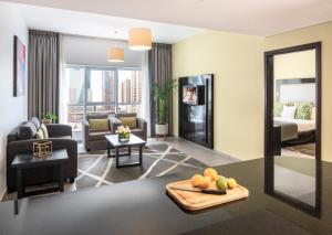 迪拜Citadines Metro Central Hotel Apartments的客厅配有沙发和1张床