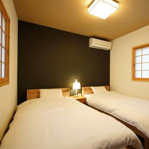 南阿苏村Ryokoji Temple的一张黑墙客房内的两张床
