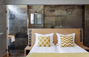 扎科帕内Kamieniec 27 Bed & Breakfast的一间卧室配有黄色和白色枕头的床