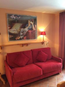 维拉巴萨Residenze Sonnenschein Casa Rossa的客厅里一张红色的沙发,墙上挂着一幅画