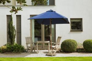 诺丁汉哈特酒店的蓝色伞下的一张桌子和两把椅子
