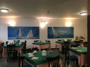 代森扎诺-德尔加达广场酒店的一间用餐室,墙上设有绿色的桌椅和帆船