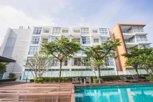 功孟海滩At Seacondo-1 Bedroom-A20的公寓大楼设有游泳池和树木