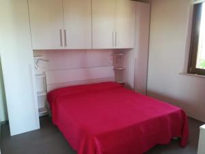 马洛塔Tulipano Appartamenti的白色橱柜内的一张红色的床