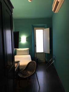 佛罗伦萨Hotel Universo - WTB Hotels的卧室配有1张床、1张桌子和1把椅子