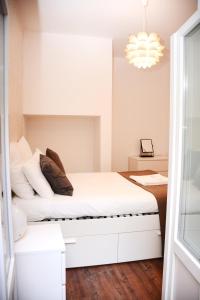 里斯本福利斯特公寓的卧室配有白色的床和吊灯。
