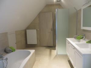 尼乌波特B&B 't Hannonshof的白色的浴室设有浴缸和水槽。