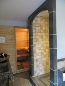 尼乌波特B&B 't Hannonshof的木墙旁的浴室设有步入式淋浴间