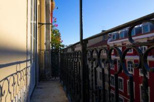 里斯本Apartment Baixa/Chiado view Tagus的火车旁的建筑围栏
