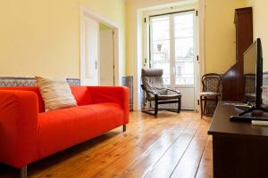 里斯本Apartment Baixa/Chiado view Tagus的客厅设有红色的沙发和木地板