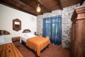 帕纳哈切尔VILLAS JUCANYA Super Higienizadas的一间卧室设有一张床和石墙
