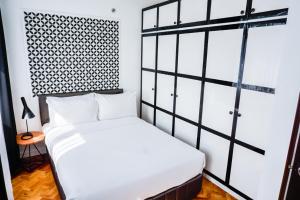马尼拉Parque España Residence Hotel Managed by HII的卧室配有白色的床和窗户。