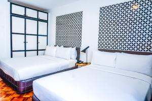 马尼拉Parque España Residence Hotel Managed by HII的一间卧室设有两张床和窗户。