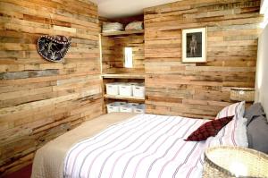 开普敦Dancers' Cottages的一间卧室配有木墙和一张床